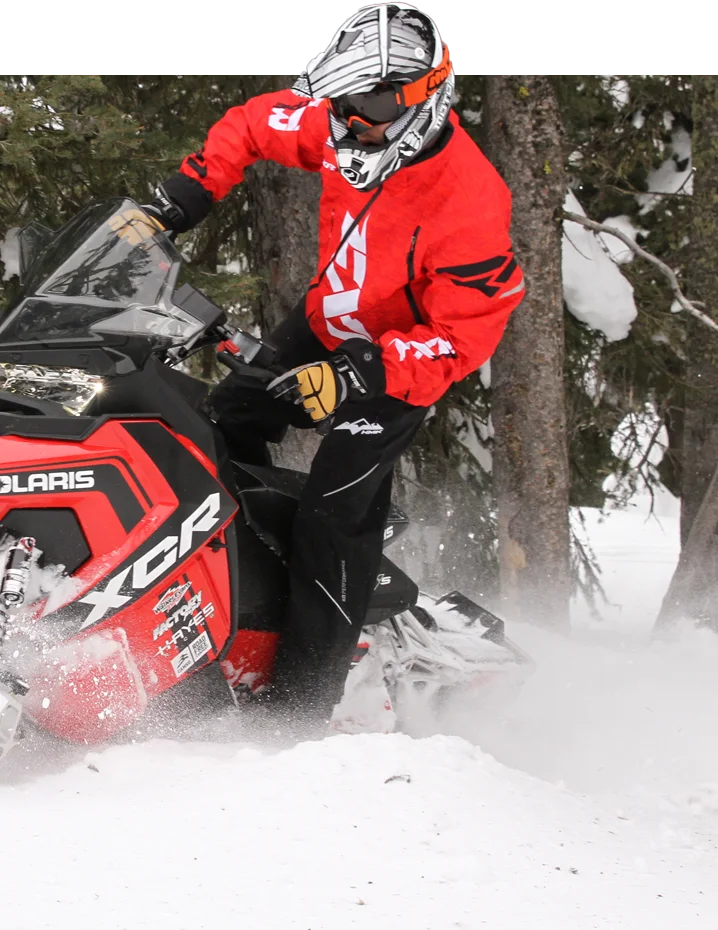 a snowmobiler riding through the snow